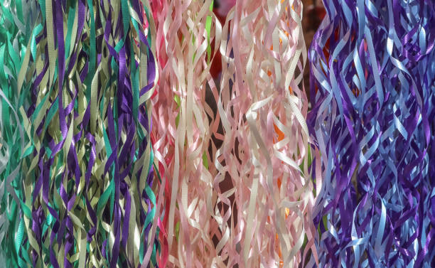 фон разноцветных ленточеных стримеров, висящих вертикально, включая зелено-фиолетовый розовый белый и желтый - snake white curled up animal стоковые фото и изображения