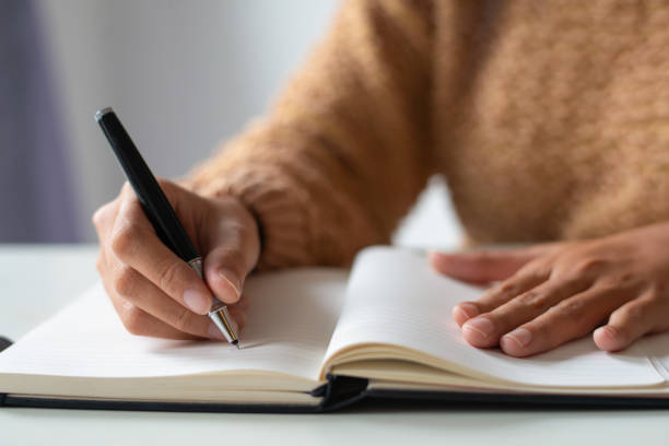 istock Close-up of businesswoman making notes in personal organizer 1092004606