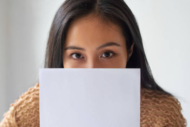 istock Serious attractive Asian lady covering mouth behind document 1092004672