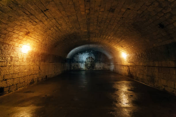 large empty old dark underground vaulted cellar - church indoors inside of monastery imagens e fotografias de stock