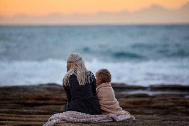 istock Woman with girl cuddling on seashore 1092007804