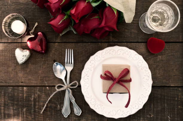 san valentino cenare con vino e un regalo su un vecchio tavolo di legno - dozen roses immagine foto e immagini stock