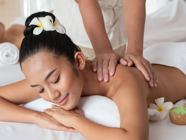 femme asiatique sont massage relaxant d’épaule dans le salon spa. massage thaïlandais de la santé. sélectionnez main focus de masseuse - life back lit people happiness photos et images de collection