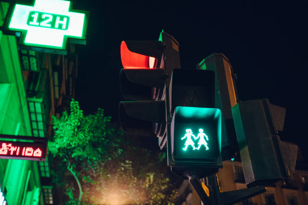 Madrid, Spain - December 2018: Street light, located in what is known as the gay town of Chueca in Madrid, lights up showing two woman holding hands to cross the street.