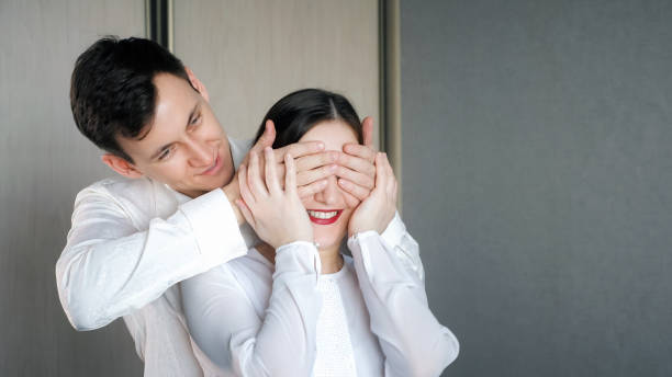 istock man closes his is girlfriend's eyes to make surprise 1092059688