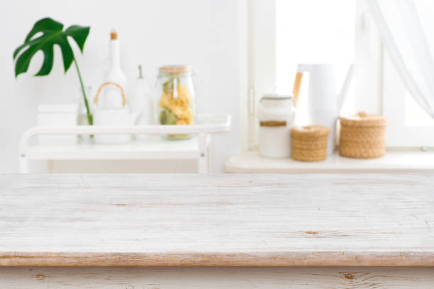 istock Wooden table top on blurred kitchen window and shelves background 1092062952