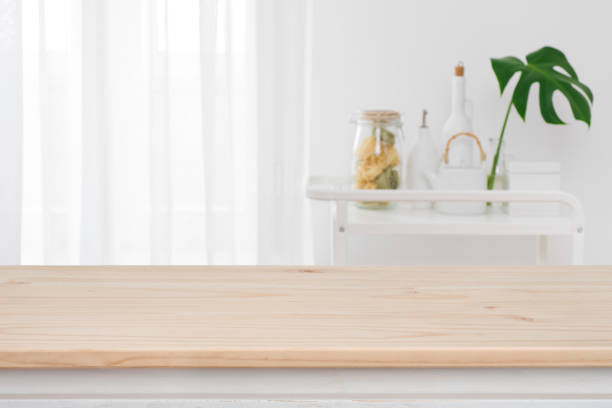 istock Blurred kitchen window, shelves background with wooden tabletop in front 1092063050