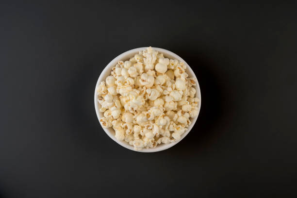 Popcorn viewed from above on dark background Popcorn, Snack, Food, Corn, Food and Drink popcorn snack bowl isolated stock pictures, royalty-free photos & images