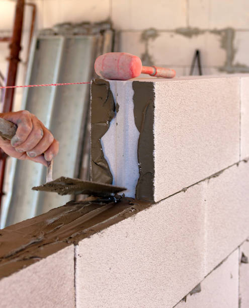 pedreiro executa um concreto aerado de blocos de alvenaria interna. foco seletivo - mason brick bricklayer installing - fotografias e filmes do acervo