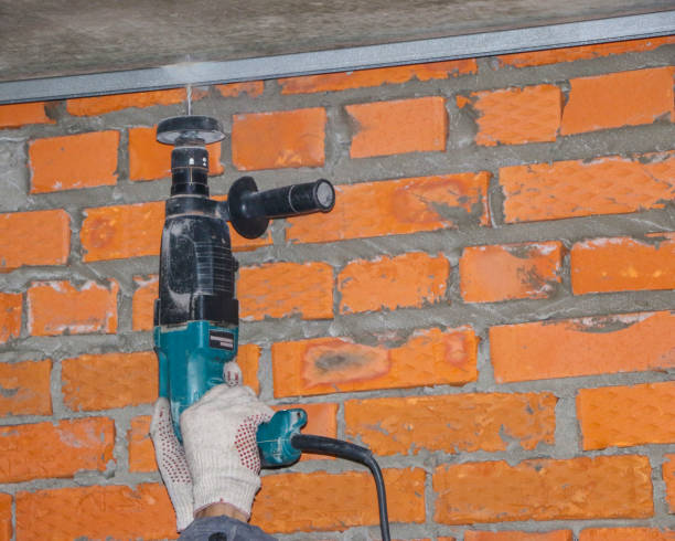 istock men's hands in  working gloves, drill  hole in  steel profiles, to install  frame under  insulation. 1092069154