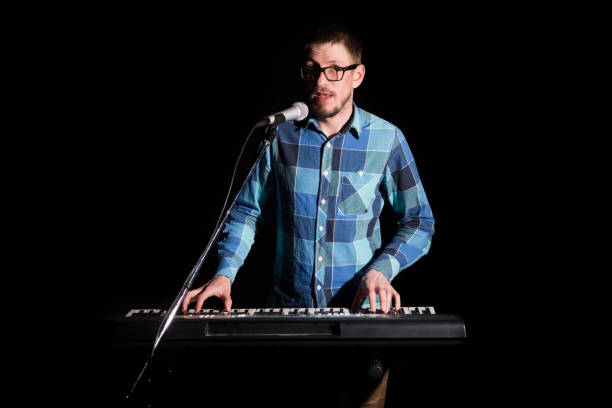 istock A young man playing on a synthesizer and singing on dark background 1092069538