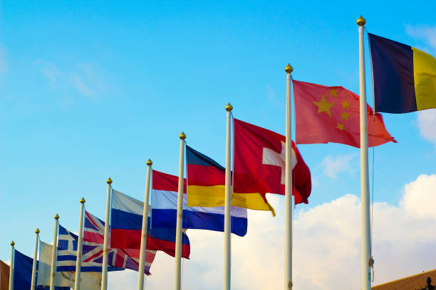 istock Flags of different countries flapping in wind against blue sky 1092071354