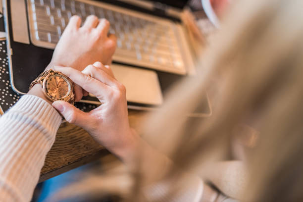 istock Unrecognizable young woman checking time while working on laptop 1092076282