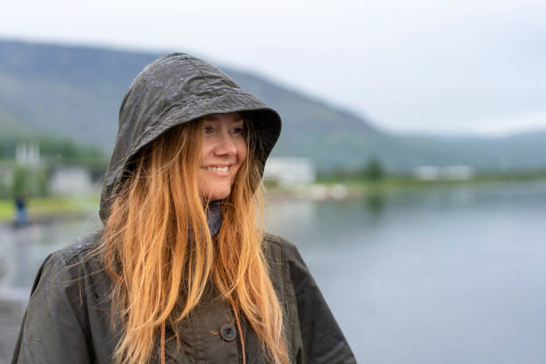 istock Thoughtful smiling woman in raincoat looking away 1092078600