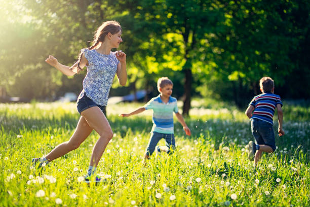 voluntad de niños corriendo en el prado de diente de león - child running playing tag fotografías e imágenes de stock