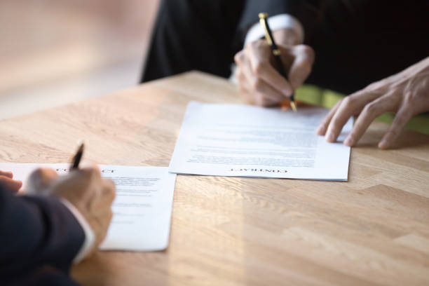 istock Close up businessmen hands holds pens signing contract 1092087564