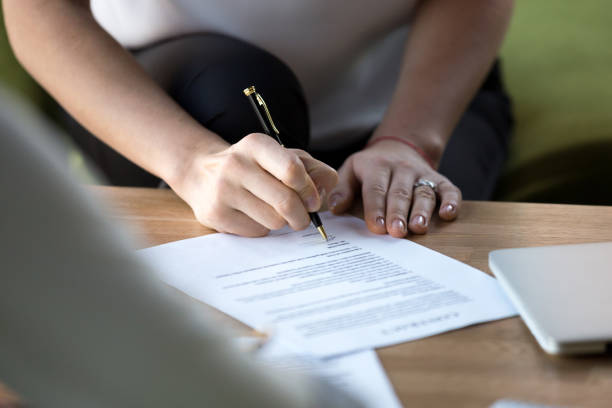 istock Female hand hold ballpoint after checking paper ready sign it 1092087616
