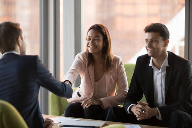 imprenditori multirazziali felici che si stringono la mano durante l'incontro aziendale - middle eastern ethnicity business greeting handshake foto e immagini stock