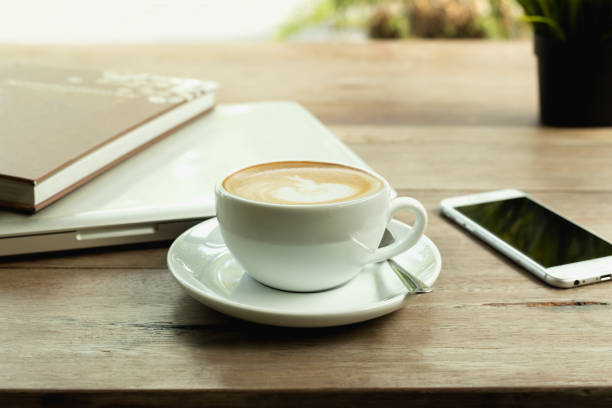 istock Coffee cup with laptop computer and cell phone on wooden table. 1092090688
