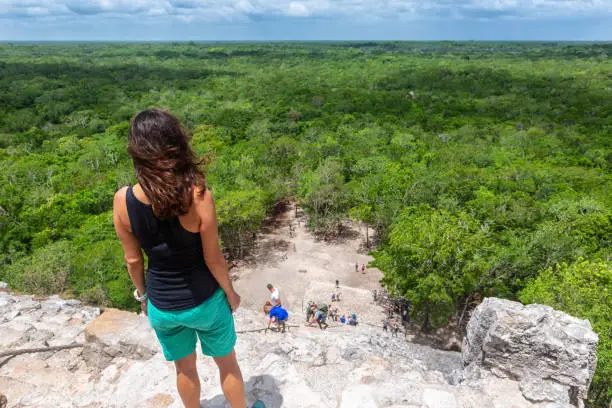 Photo of Traveler woman looks the Nohoch Mul pyramid in Coba, Yucatan, Mexico