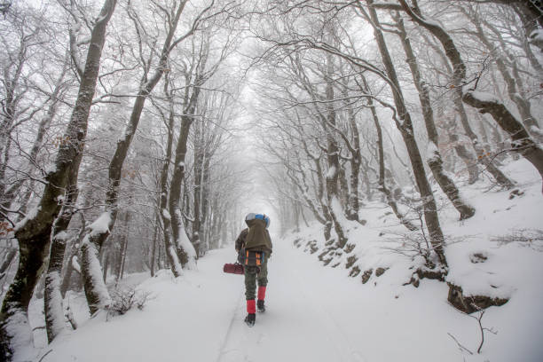 Adult Backpacker Hiking on a Snowed Hill.