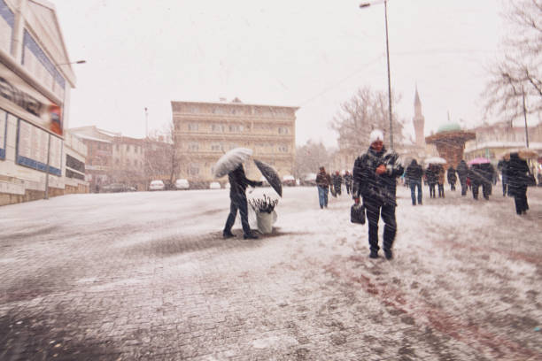 scene della vita di strada di tutti i giorni in turchia. venditore di ombrelli e pedoni in una giornata nevosa - sleet foto e immagini stock