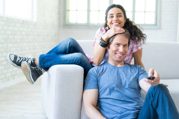 istock Couple sitting on sofa at home and watching TV 1092107642