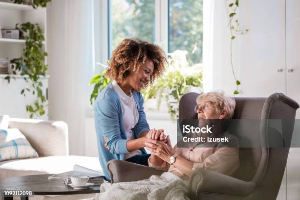 Cheerful Nurse Taking Care Of Eldery Lady Stock Photo - Download Image Now - Alzheimer's Disease, 70-79 Years, A Helping Hand