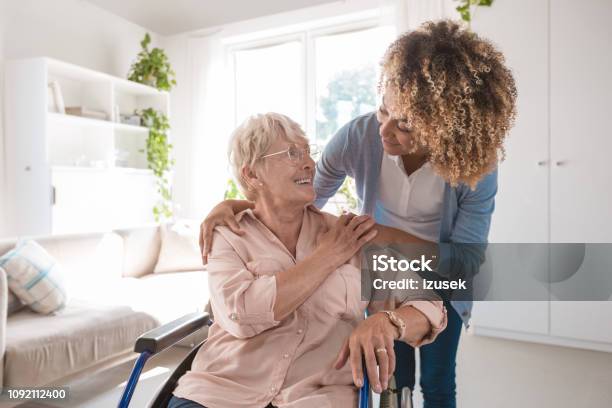 Cheerful Nurse Taking Care Of Eldery Lady Stock Photo - Download Image Now - Senior Adult, Wheelchair, Community Outreach