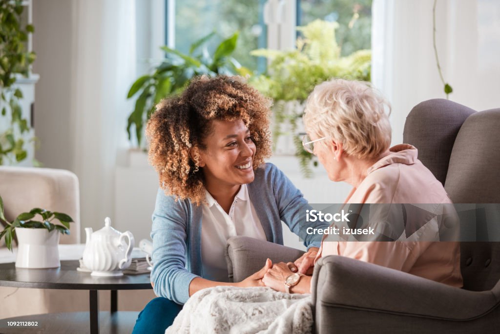 Freundliche Krankenschwester unterstützt eine ältere Dame - Lizenzfrei Alter Erwachsener Stock-Foto