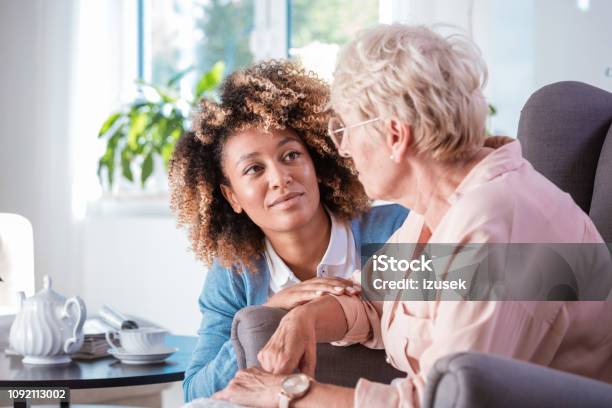 Friendly Nurse Taking Care Of Eldery Lady Stock Photo - Download Image Now - Alzheimer's Disease, Community Outreach, Healthcare Worker
