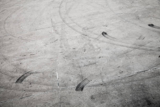 istock Dark tire tracks on gray concrete road 1092115666