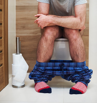 Young man in pain gong through his morning routine at toilet