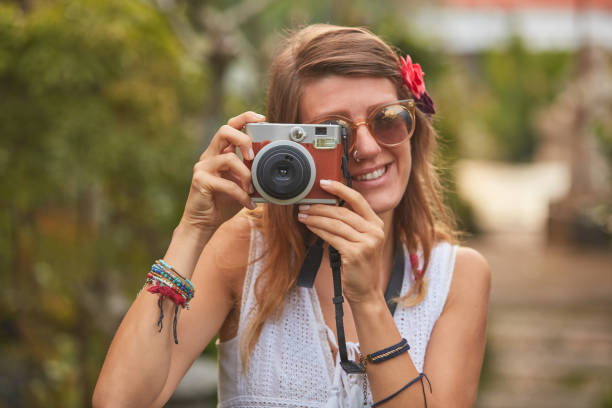 istock iirl posing with retro vintage camera outdoors. 1092119274