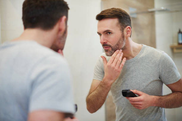 mature man with electric razor shaving - stubble imagens e fotografias de stock