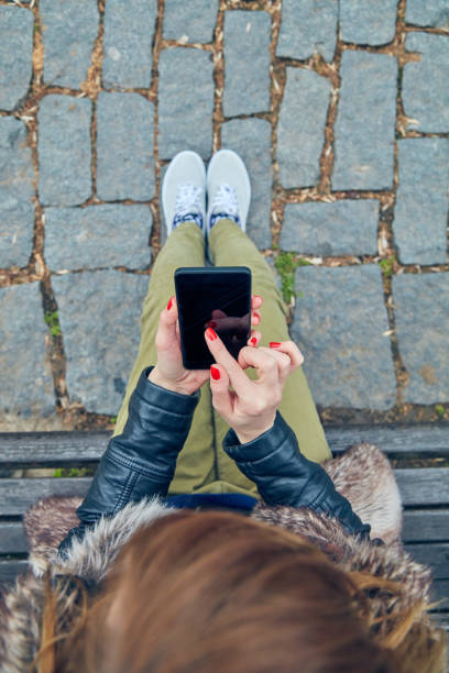 istock Woman sitting on a bench and using smartphone. 1092122108