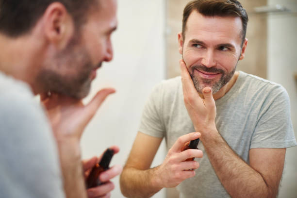 istock Smiling man applying beauty product on his face 1092122138