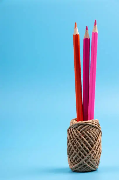 color pencils and string basket on blue background