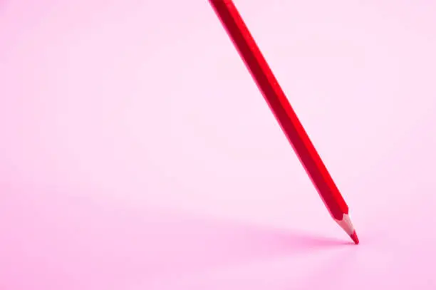 red pencil Floating on red background