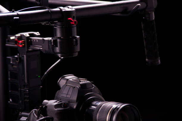istock System stabilization video camera and lens on steady equipment support such as gimbal steady or stabilized. Black background 1092134586