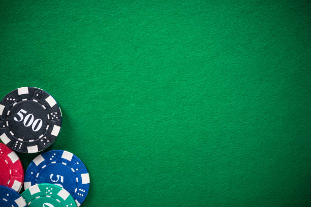 Casino chips on green empty cloth, spotlight background.