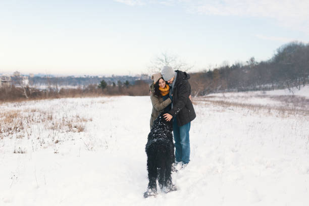 istock A couple enjoying winter while walking their big black dog havin 1092143174