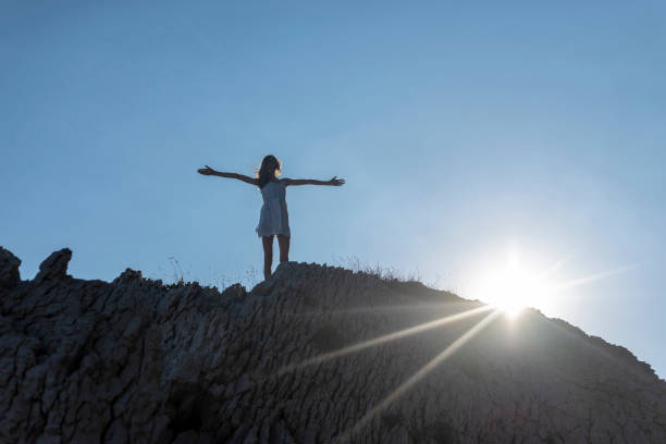 istock girl cheering on the rock 1092147378