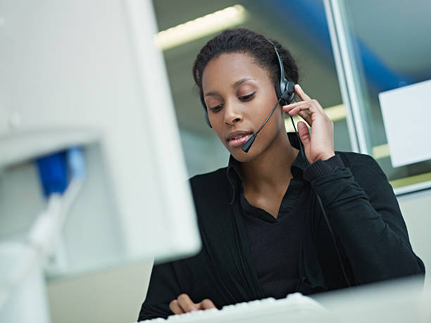 mulher a trabalhar no centro de chamadas telefónicas - african descent customer service representative computer service imagens e fotografias de stock