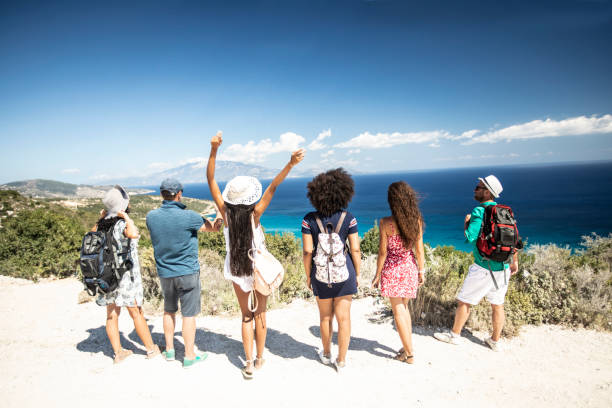 istock Group of backpackers standing on top and looking at sea 1092159284