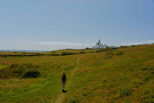 istock Girl walking grass lighthouse 1092160304