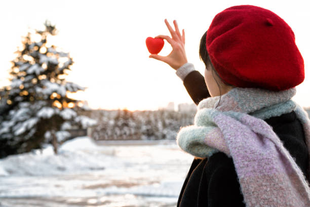 istock Woman hands holding red heart at sunset 1092160500