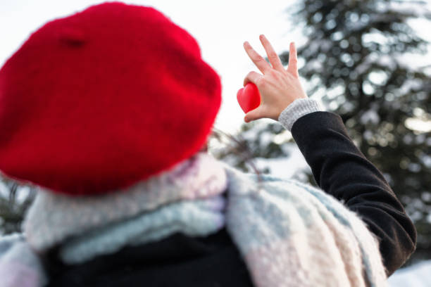 istock Woman hands holding red heart at sunset 1092160502