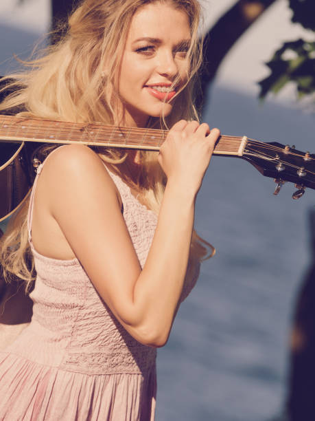 istock Woman playing acoustic guitar in park 1092162420