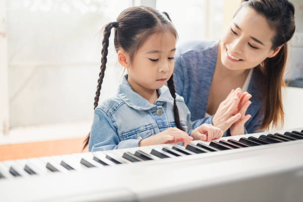 asiatische junge pianistin lehrer unterricht studentin kind klavierspielen, musik-bildungskonzept - togetherness learning playful mother stock-fotos und bilder